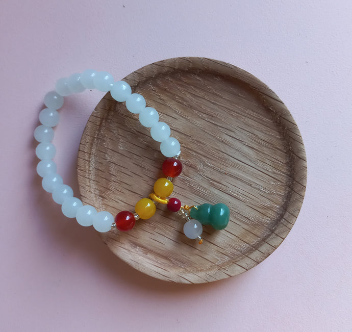 White, amber and red stone beaded bracelet with green lucky charm and bead. 
