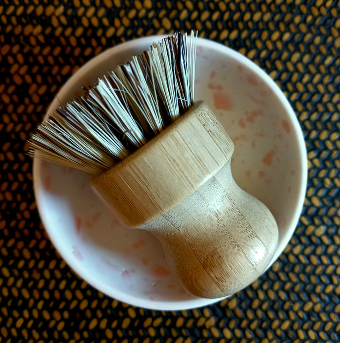 Small bamboo and natural bristle pot scrubbing brush that fits in the palm of your hand